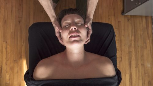 Mains de Éliane massant la nuque de Anouk; vue des mains posées sur les côtés du visage